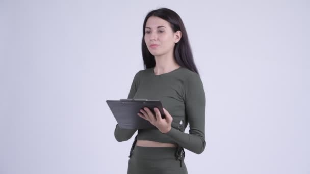 Young beautiful woman directing while holding clipboard — Stock Video