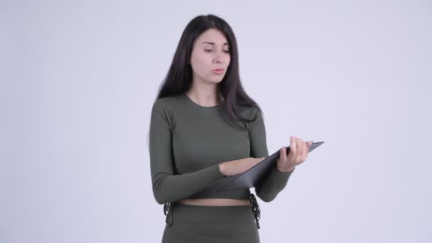 Fiatal hangsúlyozta nő mutatja a vágólapra, és így remek le — Stock videók