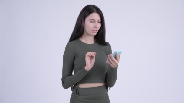 Feliz joven hermosa mujer usando el teléfono y recibiendo buenas noticias — Vídeo de stock