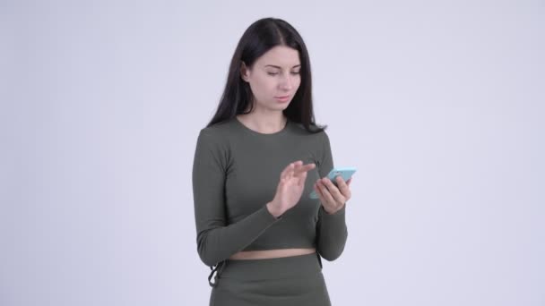 Stressed young woman using phone and getting bad news — Stock Video