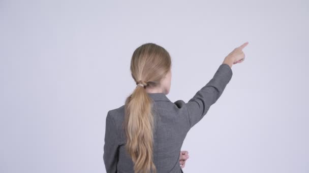 Vista posteriore della giovane donna d'affari bionda che punta il dito e dirige — Video Stock