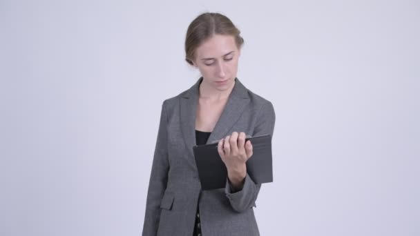 Счастливая молодая блондинка-бизнесмен показывает планшет и показывает большие пальцы вверх — стоковое видео