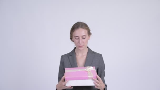 Feliz joven rubia empresaria abriendo caja de regalo y mirando sorprendido — Vídeos de Stock