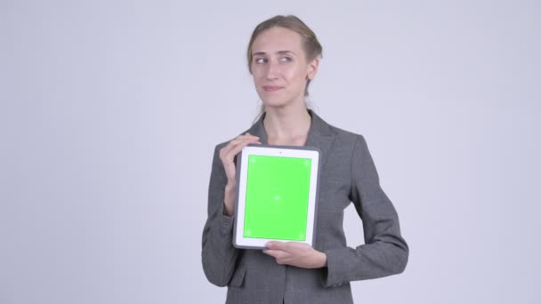 Heureuse jeune femme d'affaires blonde penser tout en montrant tablette numérique 
