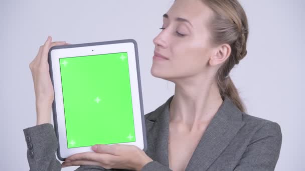 Visage de heureuse jeune femme d'affaires blonde montrant tablette numérique 