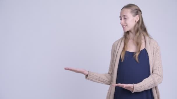 Gelukkig jonge mooie zwangere vrouw iets tonen — Stockvideo