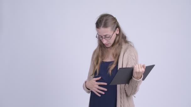 Счастливая беременная женщина читает книгу и разговаривает со своим ребенком — стоковое видео