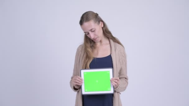 Jovem grávida feliz pensando ao mostrar tablet digital — Vídeo de Stock