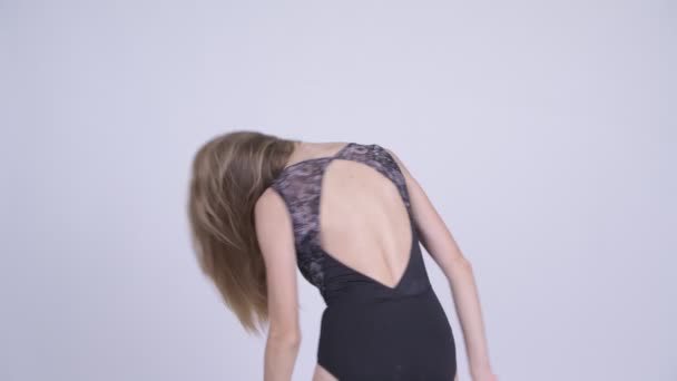 Glückliche junge blonde Frau im Badeanzug, die ihr Haar umblättert — Stockvideo