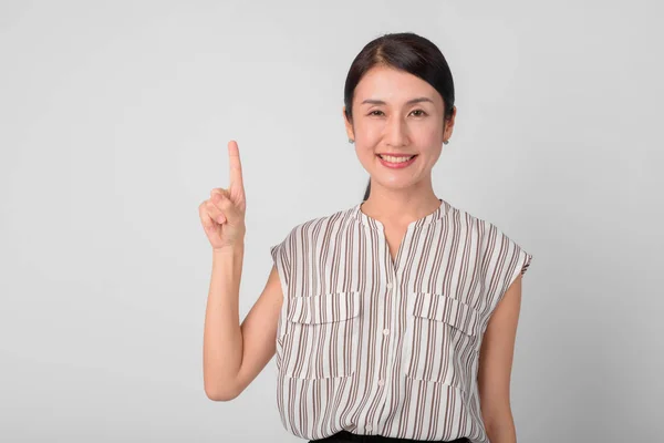 Retrato de feliz bela empresária japonesa apontando para cima — Fotografia de Stock