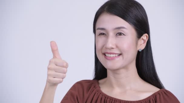 Лицо счастливой красивой азиатской женщины, подающей большие пальцы вверх — стоковое видео