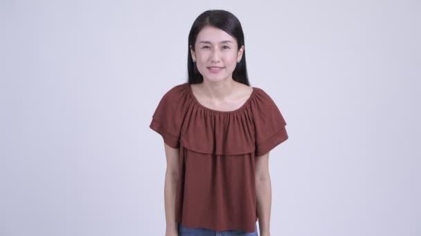 Счастливая красивая азиатка представляет что-то — стоковое видео