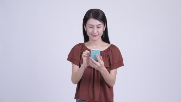 Ευτυχής όμορφη γυναίκα της Ασίας χρήση τηλεφώνου και κοιτάζοντας έκπληκτοι — Αρχείο Βίντεο