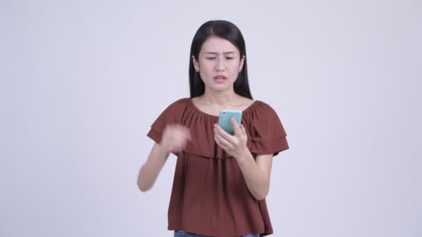 Stressed Asian woman using phone and getting bad news — Stock Video