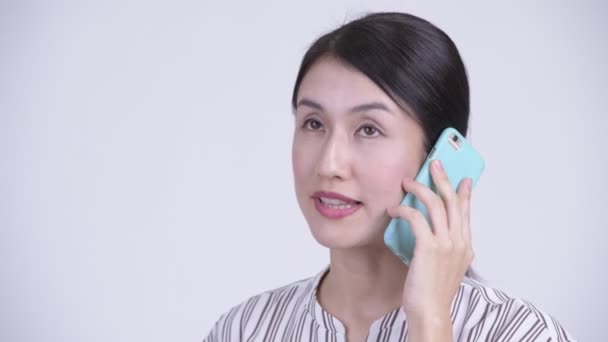Tvář šťastné krásné asijské podnikatelka mluvil po telefonu — Stock video