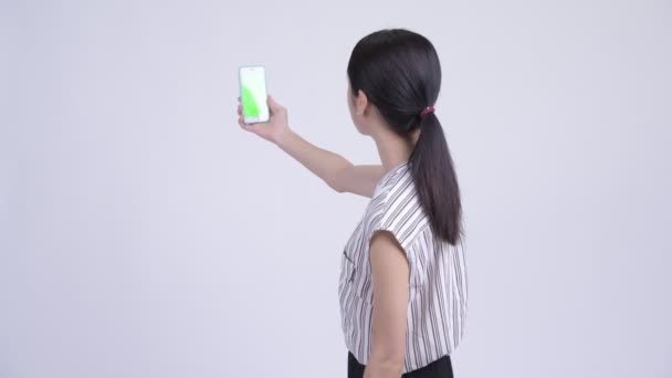 Feliz hermosa mujer de negocios asiática video llamadas y mostrando el teléfono — Vídeo de stock
