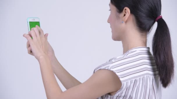 電話を使用して幸せな美しいアジア女性実業家の背面図 — ストック動画