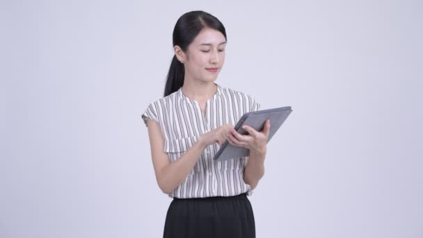 Heureuse belle femme d'affaires asiatique penser tout en utilisant une tablette numérique — Video