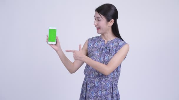 Heureuse femme enceinte asiatique montrant téléphone et donnant pouces vers le haut — Video