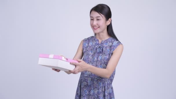 Happy pregnant Asian woman shaking gift box — Stock Video