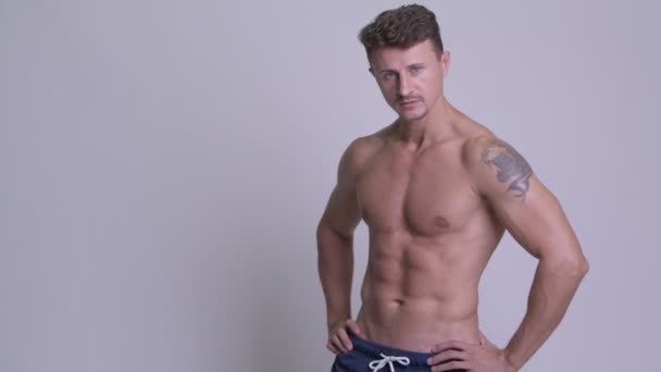 Muskulöser gutaussehender bärtiger Mann, der hemdlos lächelt — Stockvideo