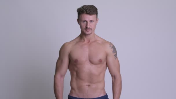 Svalnatý šťastný vousatý muž s úsměvem shirtless proti Bílému pozadí — Stock video