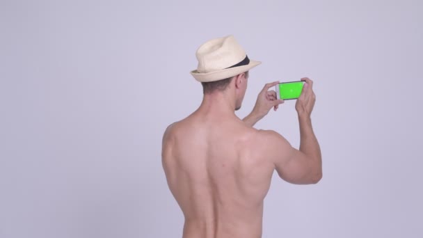 Arkadan görünüş kas sakallı turist adamın telefonu ile fotoğraf çekimi — Stok video