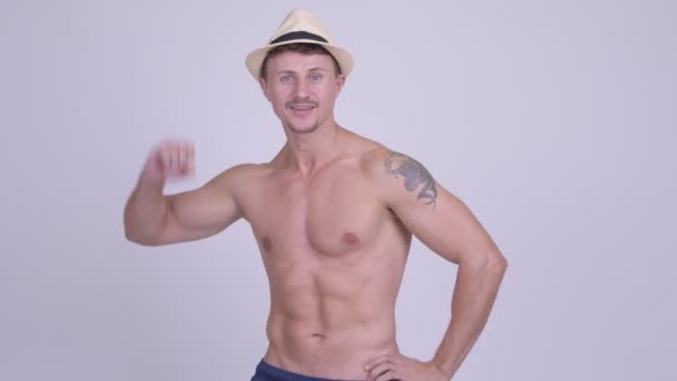 Happy muscular bearded tourist man with fists raised shirtless — Stock Video