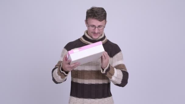 Hombre barbudo feliz mirando sorprendido y abriendo caja de regalo — Vídeos de Stock