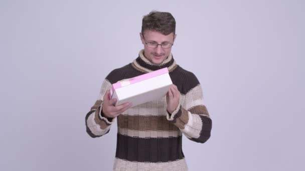 Hombre barbudo feliz mirando sorprendido y abriendo caja de regalo — Vídeo de stock