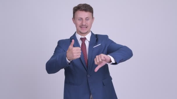 Knappe bebaarde zakenman kiezen tussen duimen omhoog en de duim omlaag — Stockvideo