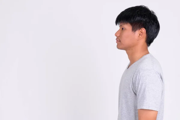 Profilo vista di giovane asiatico uomo contro bianco sfondo — Foto Stock