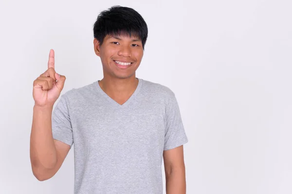 Retrato de un joven asiático feliz señalando hacia arriba — Foto de Stock