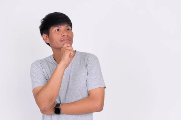 Portrait of young Asian man thinking and looking up — Stock Photo, Image