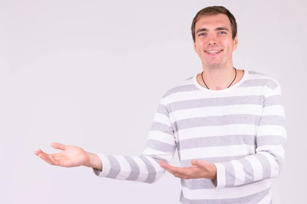 Retrato de homem feliz mostrando algo contra fundo branco — Fotografia de Stock