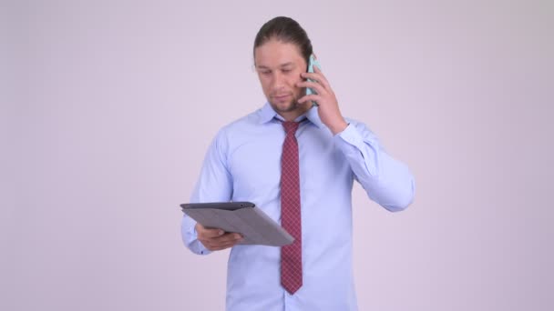 Feliz hombre de negocios guapo hablando por teléfono y utilizando la tableta digital — Vídeo de stock