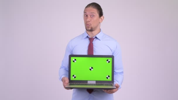 Glücklich schöner Geschäftsmann zeigt Laptop und sieht überrascht aus — Stockvideo