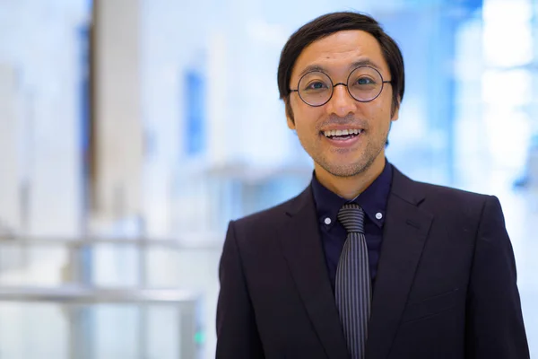 Visage de heureux homme d'affaires asiatique souriant à l'intérieur de l'immeuble de bureaux — Photo