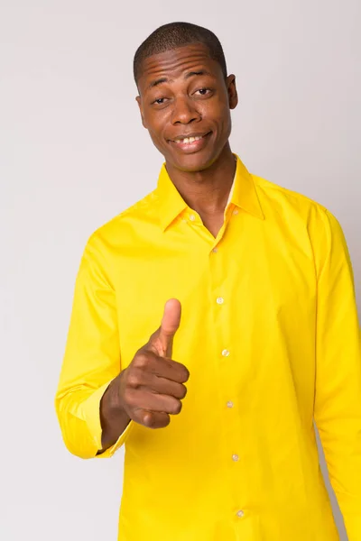 Porträt eines jungen, glücklichen, glatzköpfigen afrikanischen Geschäftsmannes, der die Daumen hebt — Stockfoto