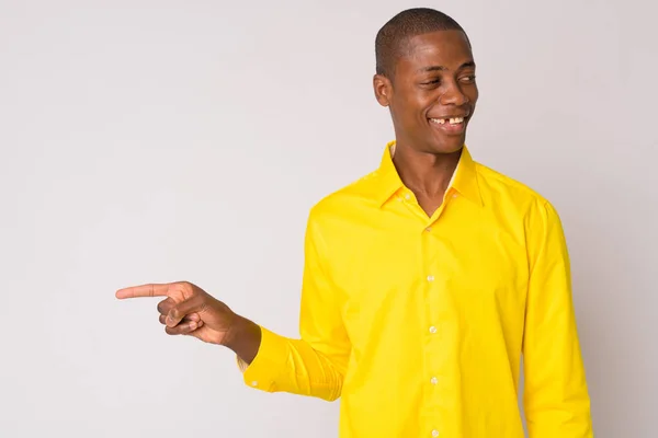 Jovem feliz homem de negócios Africano careca rindo e apontando para o lado — Fotografia de Stock
