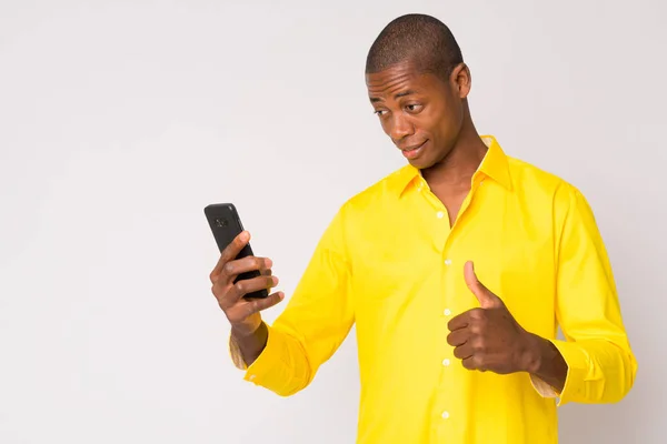 年轻快乐的秃头非洲商人用电话竖起大拇指 — 图库照片