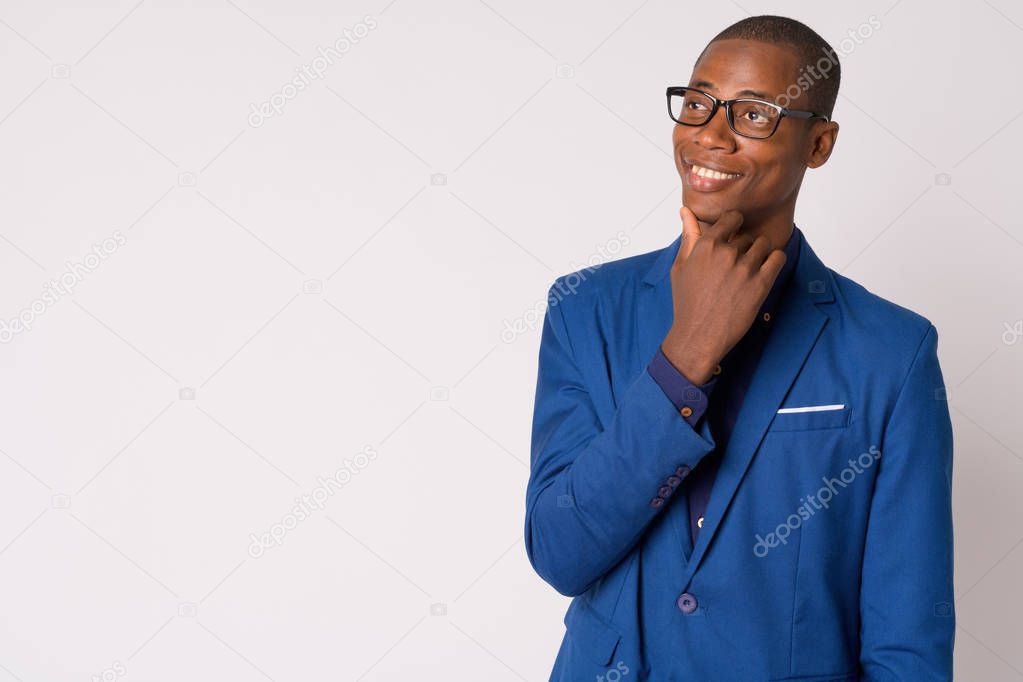 Portrait of young happy bald African businessman with eyeglasses thinking