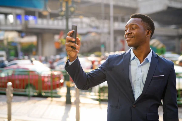 Ung vacker afrikansk affärsman tar selfie i stadens gator utomhus — Stockfoto