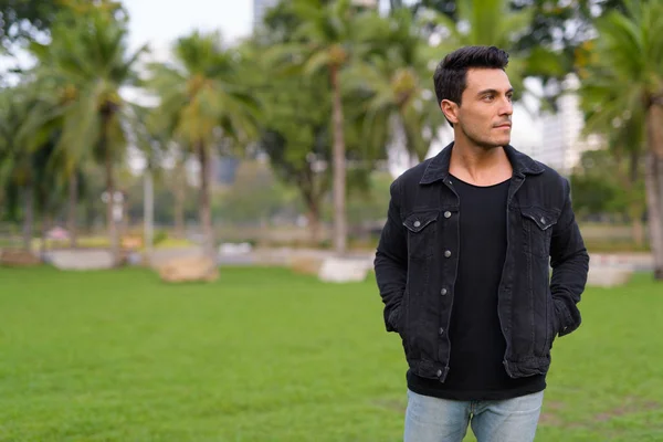 Joven hombre hispano guapo caminando en el parque al aire libre — Foto de Stock