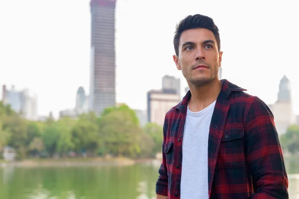 Joven hombre hipster hispano guapo pensando en el parque — Foto de Stock