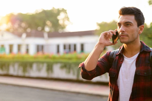 Jeune homme hipster hispanique réfléchi parlant au téléphone au parc — Photo