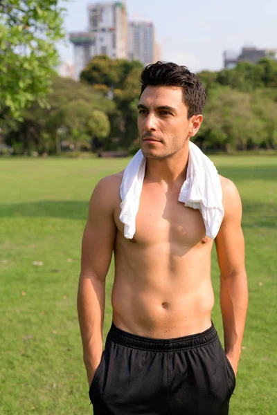 Young handsome shirtless Hispanic man thinking at the park — Stock Photo, Image
