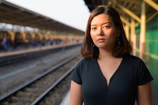Mladé krásné asijské turistické žena myslet na nádraží — Stock fotografie