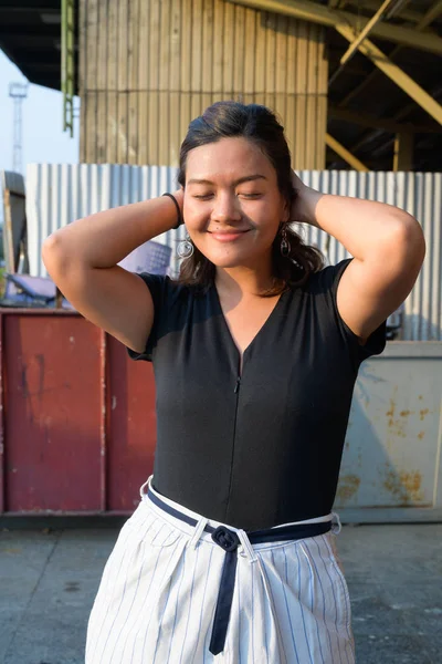 Joven mujer asiática feliz sonriendo con los ojos cerrados en la calle urbana —  Fotos de Stock