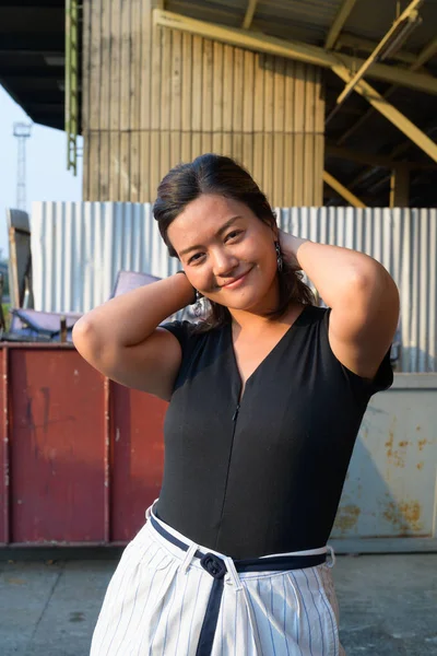 Joven feliz mujer asiática empujando el pelo de nuevo en la calle urbana —  Fotos de Stock